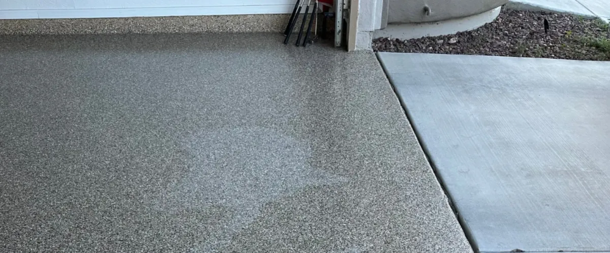 Epoxy flake coating on patio area adjacent to a concrete driveway.